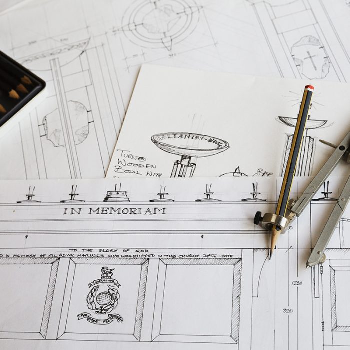 Close up of design drawings for furniture and a compass.
